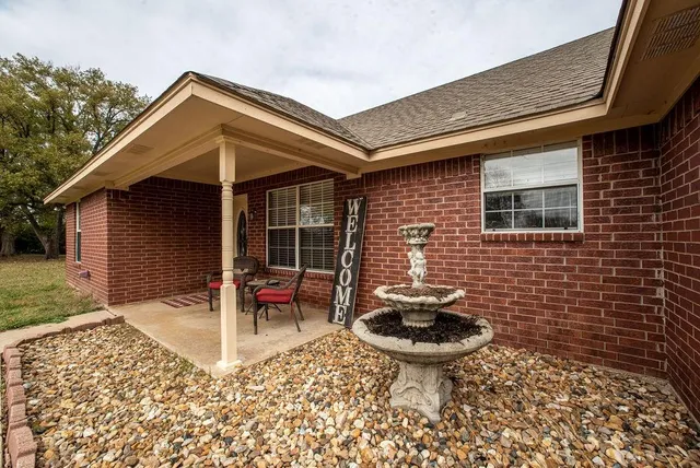 a front view of a house with garden and patio