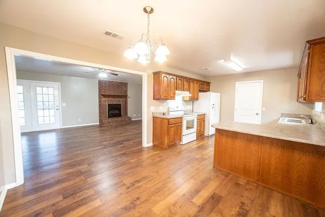 a large kitchen with cabinets and wooden floor