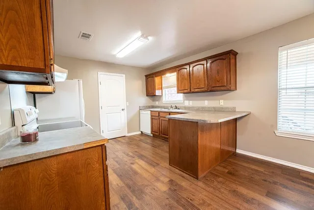 a kitchen with stainless steel appliances granite countertop a stove a sink and a microwave