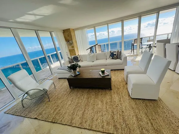 a living room with furniture and a floor to ceiling window