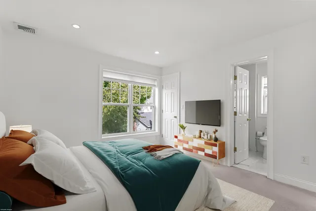 a bedroom with furniture and a flat screen tv