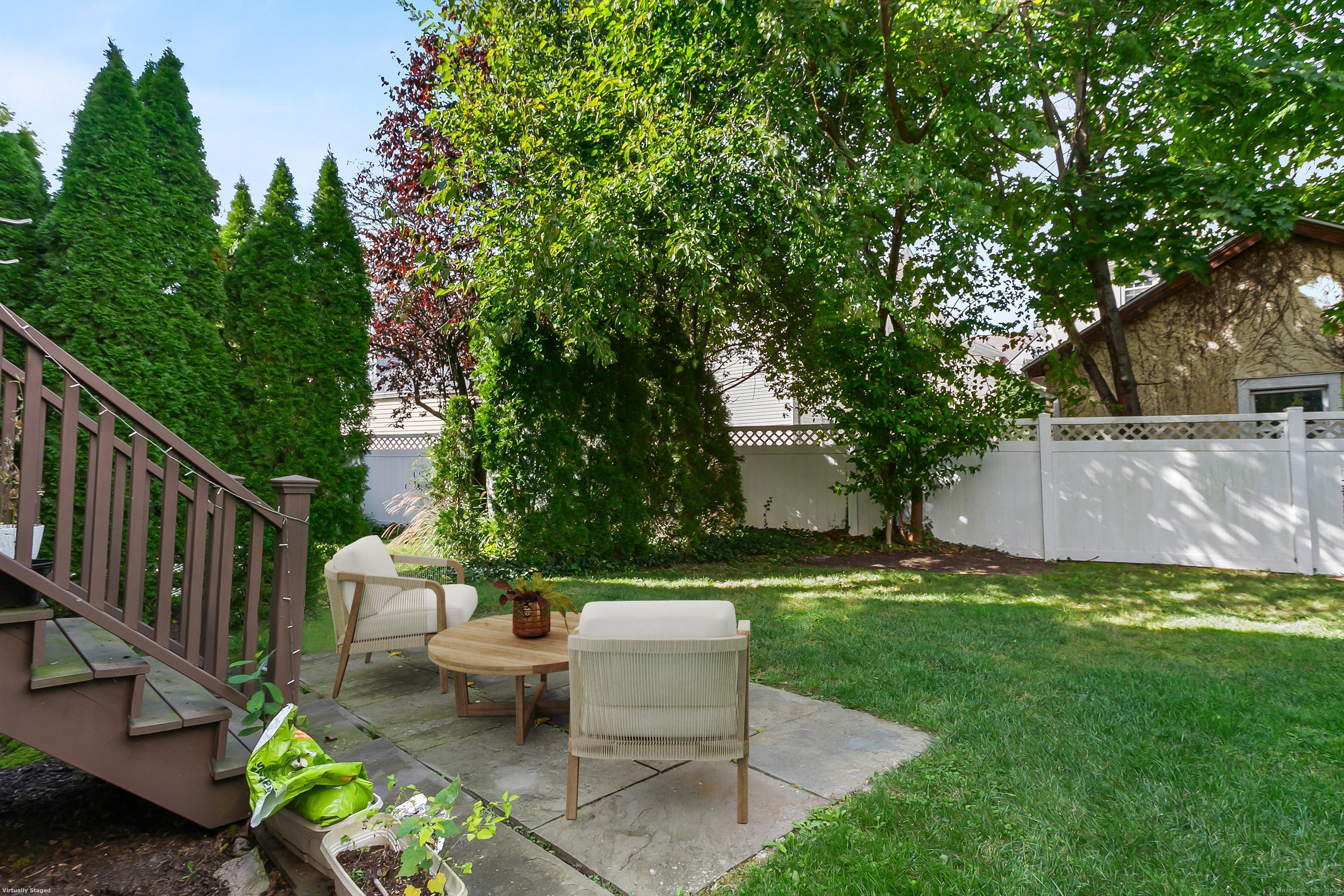 28 Rock Spring Road, Unit B2 Stamford, CT 06906 - Photo 30 of 32 a view of a patio with couches table and chairs and potted plants and large trees
