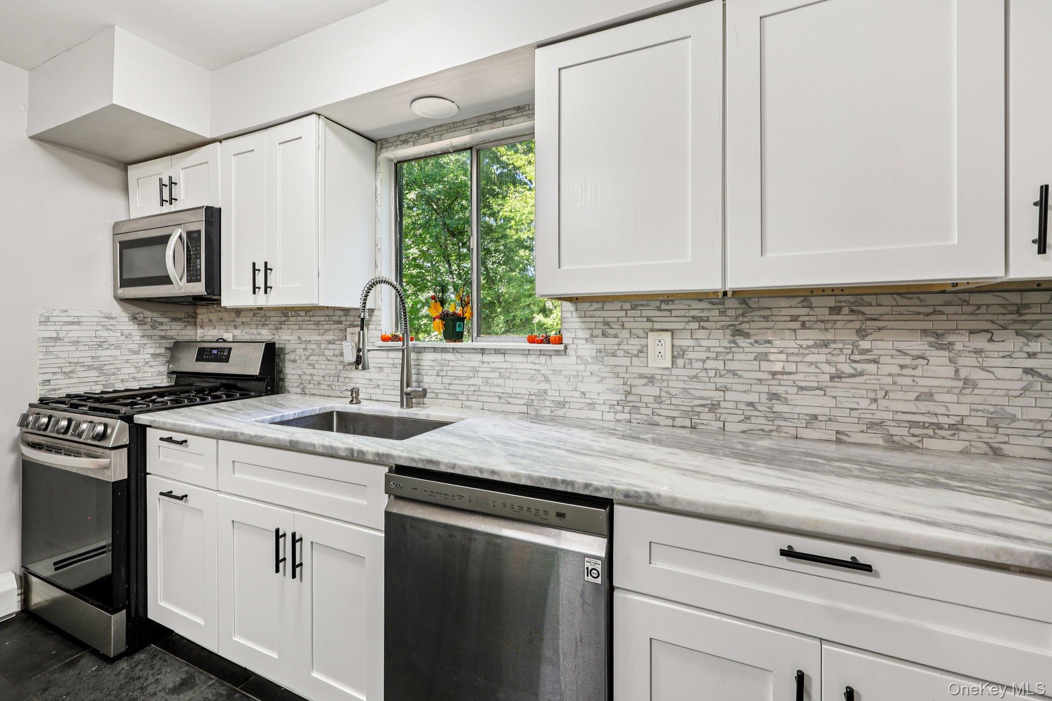 9 Crane Road Middletown, NY 10941 - Photo 14 of 31 Kitchen with white cabinets, stainless steel appliances, and beautiful backsplash
