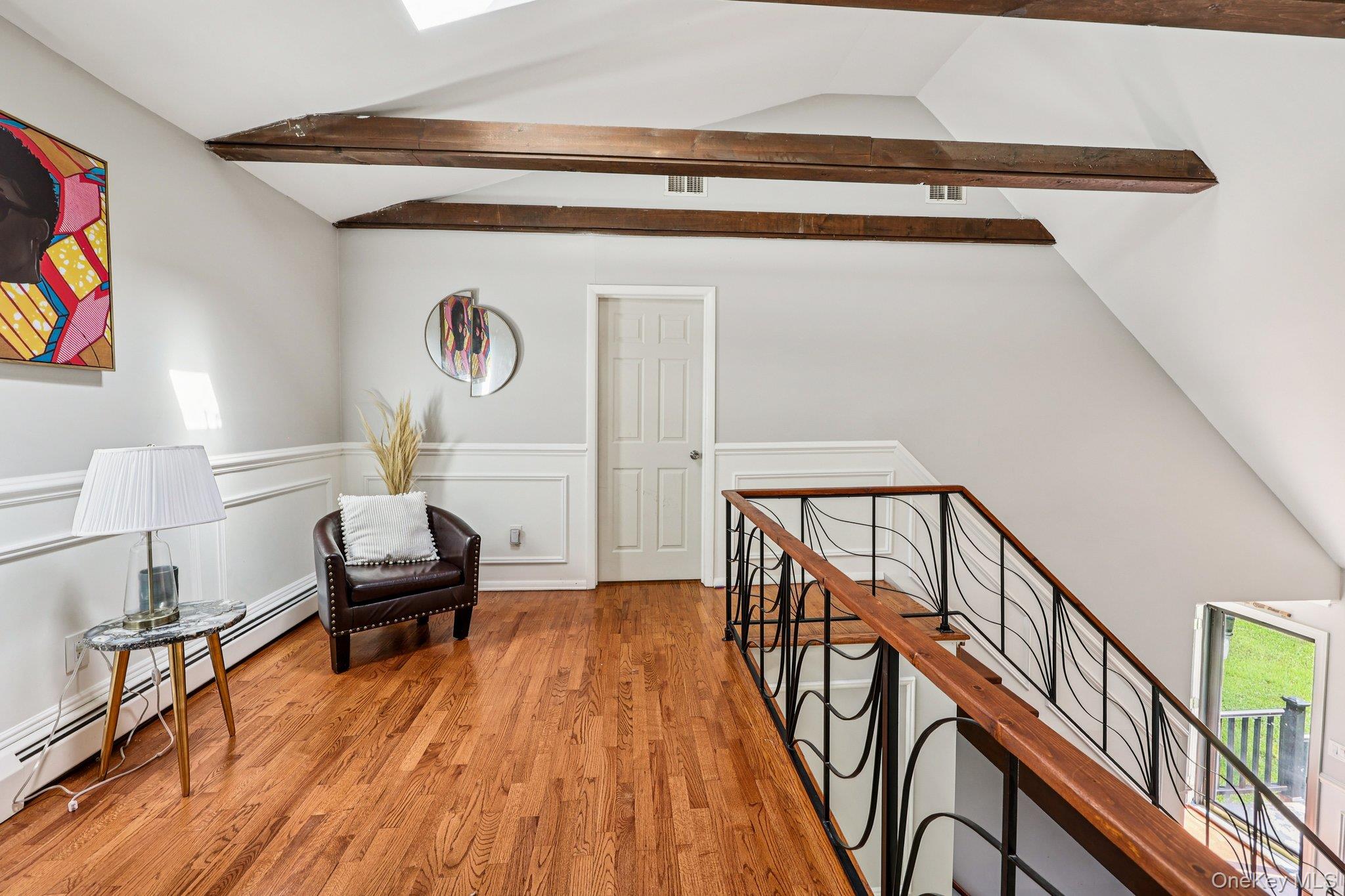 9 Crane Road Middletown, NY 10941 - Photo 15 of 31 Sitting room featuring light wood-style floors, a baseboard heating unit, an upstairs landing, a decorative wall, and a wainscoted wall