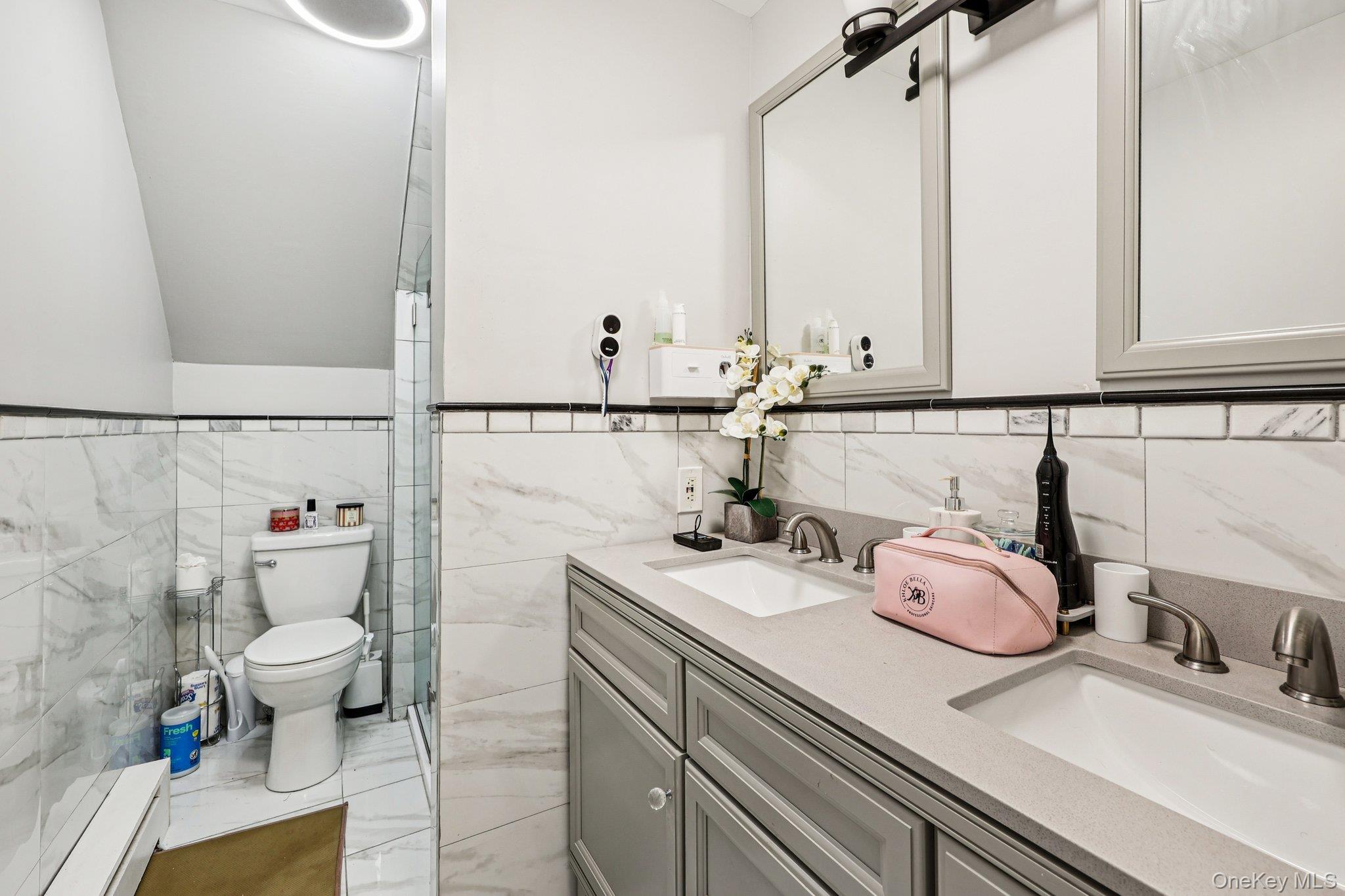 9 Crane Road Middletown, NY 10941 - Photo 19 of 31 Full bath featuring double vanity, tile walls, light marble finish floors, baseboard heating, and a shower stall