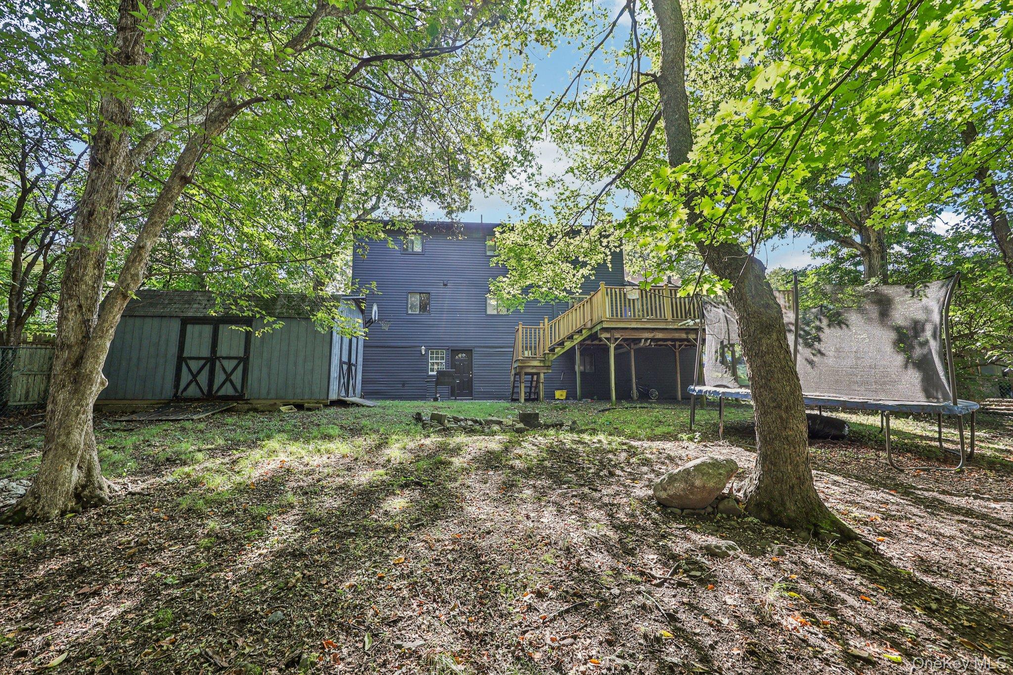 9 Crane Road Middletown, NY 10941 - Photo 22 of 31 Back of house with stairs, a trampoline, a deck, and a shed