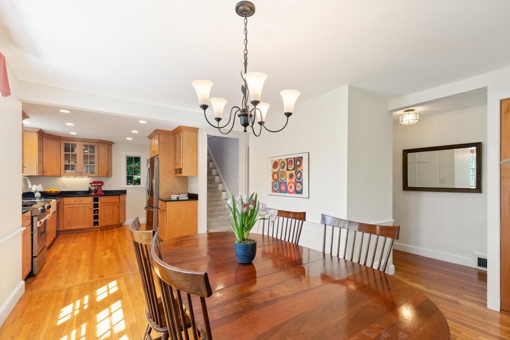 24 Blake Road Lexington, MA 02420 - Photo 17 of 30 a view of a dining room and livingroom with furniture wooden floor a rug a potted plant and a chandelier