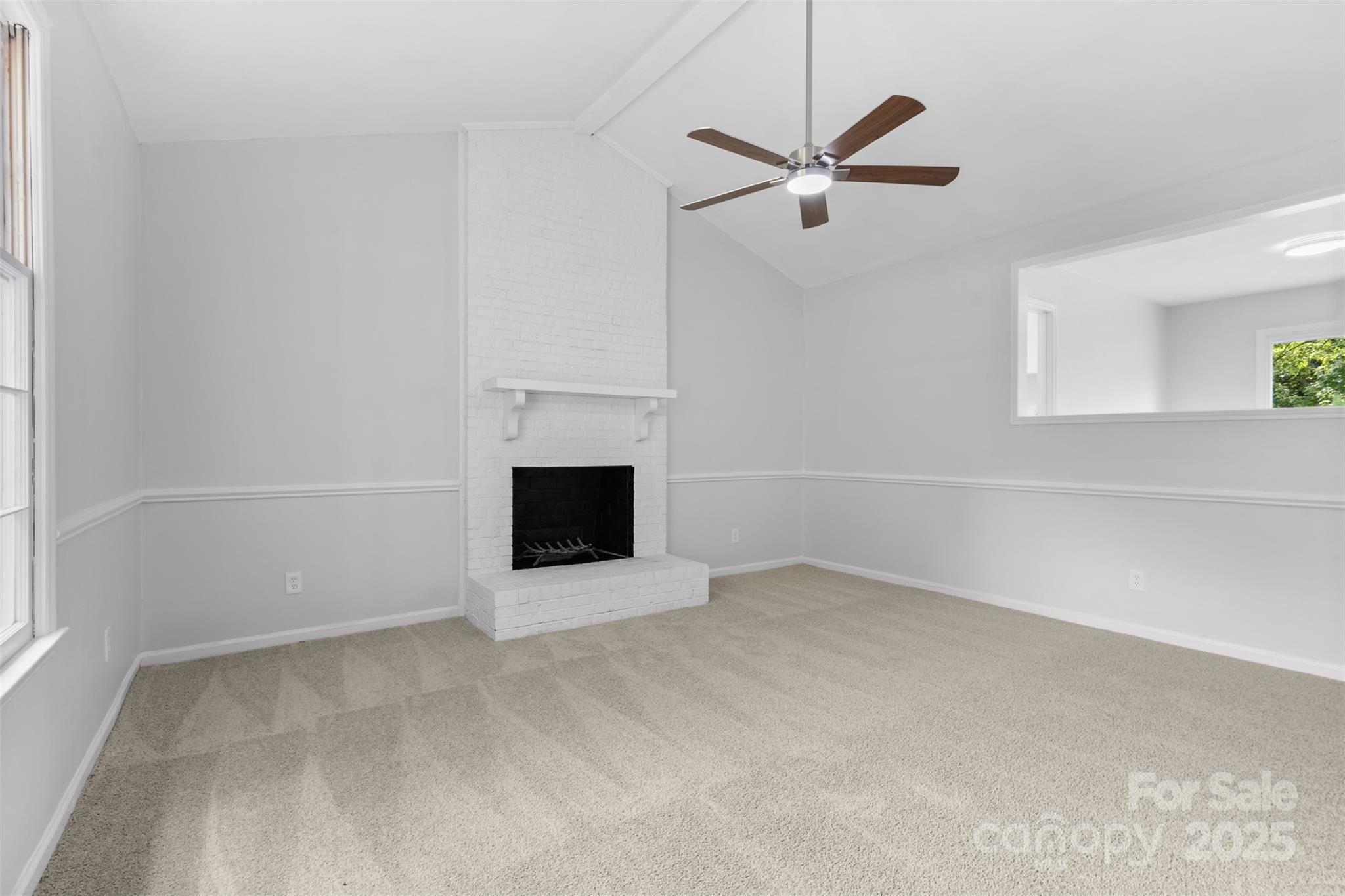 6412 Sullins Road Charlotte, NC 28214 - Photo 4 of 25 an empty room with a ceiling fan and a fireplace