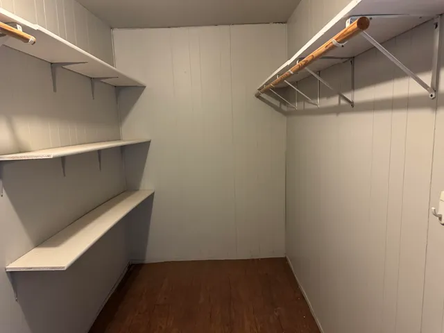 a view of empty room with wooden floor and fireplace