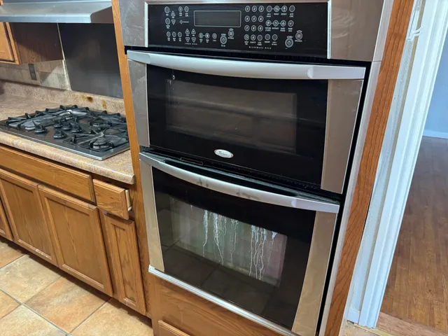 a kitchen with granite countertop a sink a stove and cabinets