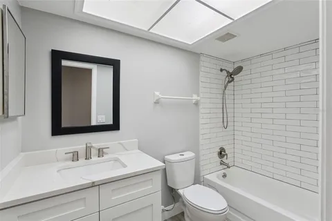 a bathroom with a sink toilet vanity and shower