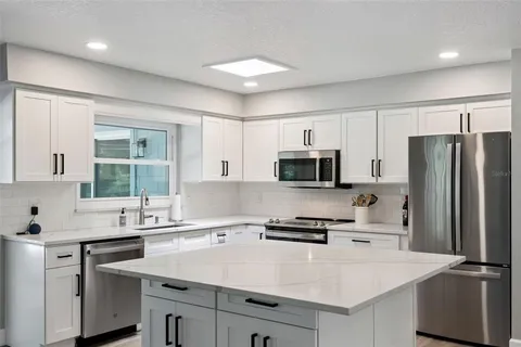 a kitchen with appliances a sink and a counter top space