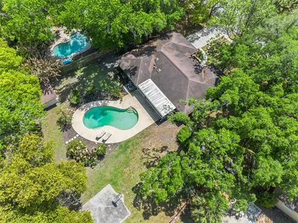 an aerial view of residential houses with outdoor space and trees