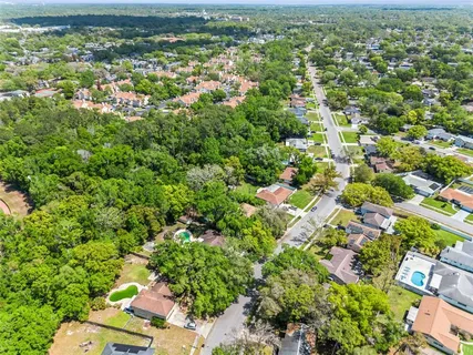 an aerial view of residential houses with outdoor space and trees