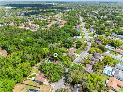 an aerial view of residential houses with outdoor space and trees