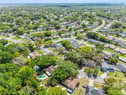 an aerial view of residential houses with outdoor space and trees