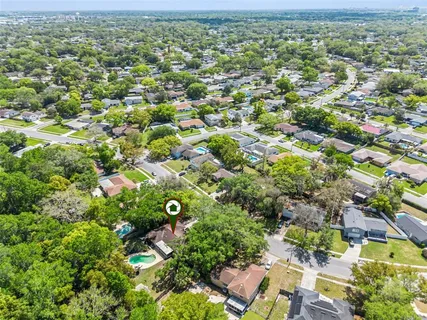 an aerial view of residential houses with outdoor space and trees