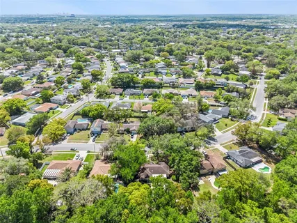 an aerial view of residential houses with outdoor space and trees