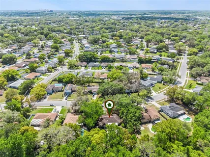 an aerial view of residential houses with outdoor space and trees
