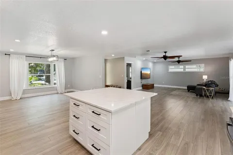 a kitchen view with wooden floor and stainless steel appliances