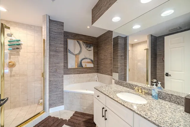 a bathroom with a tub a sink and a shower