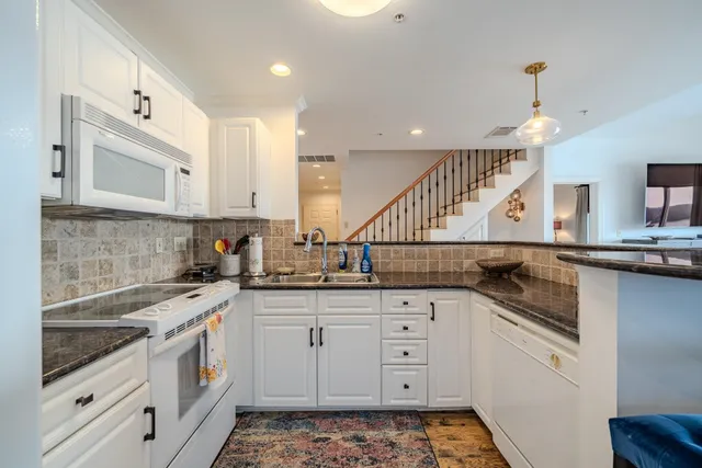 a kitchen with a dining table chairs and large window