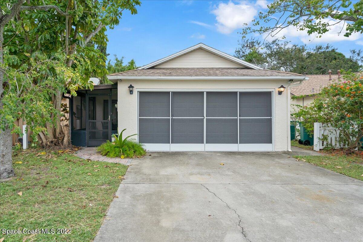 3709 Tree Line Boulevard Melbourne, FL 32935 - Photo 2 of 22 a front view of a house with a yard and garage