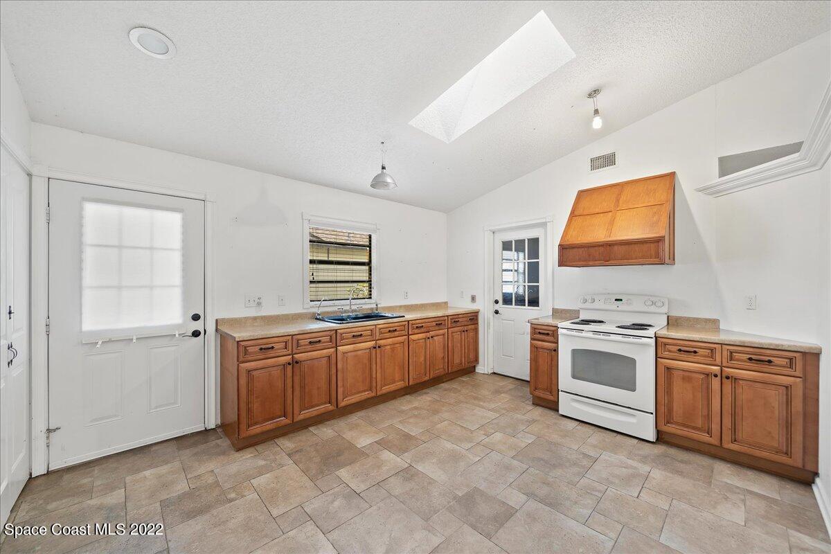 3709 Tree Line Boulevard Melbourne, FL 32935 - Photo 5 of 22 a kitchen with stainless steel appliances granite countertop a stove sink and cabinets