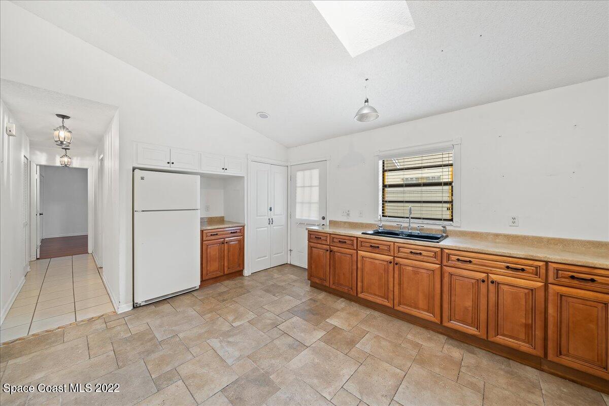 3709 Tree Line Boulevard Melbourne, FL 32935 - Photo 6 of 22 a large white kitchen with granite countertop a refrigerator and a sink