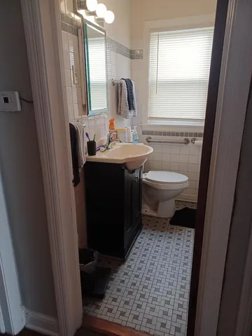 a bathroom with a toilet sink and mirror