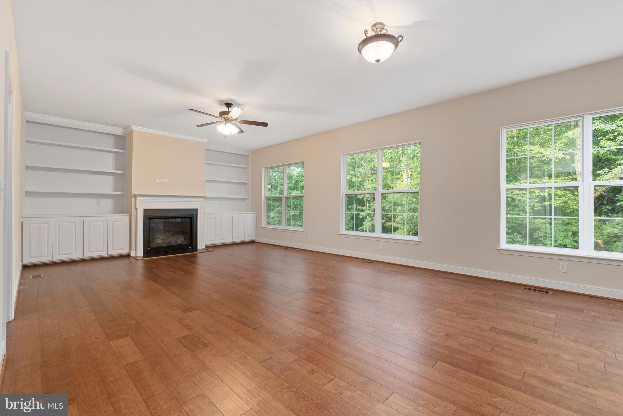 138 Sandy Ridge Road Fredericksburg, VA 22405 - Photo 13 of 30 an empty room with windows fireplace and a ceiling fan