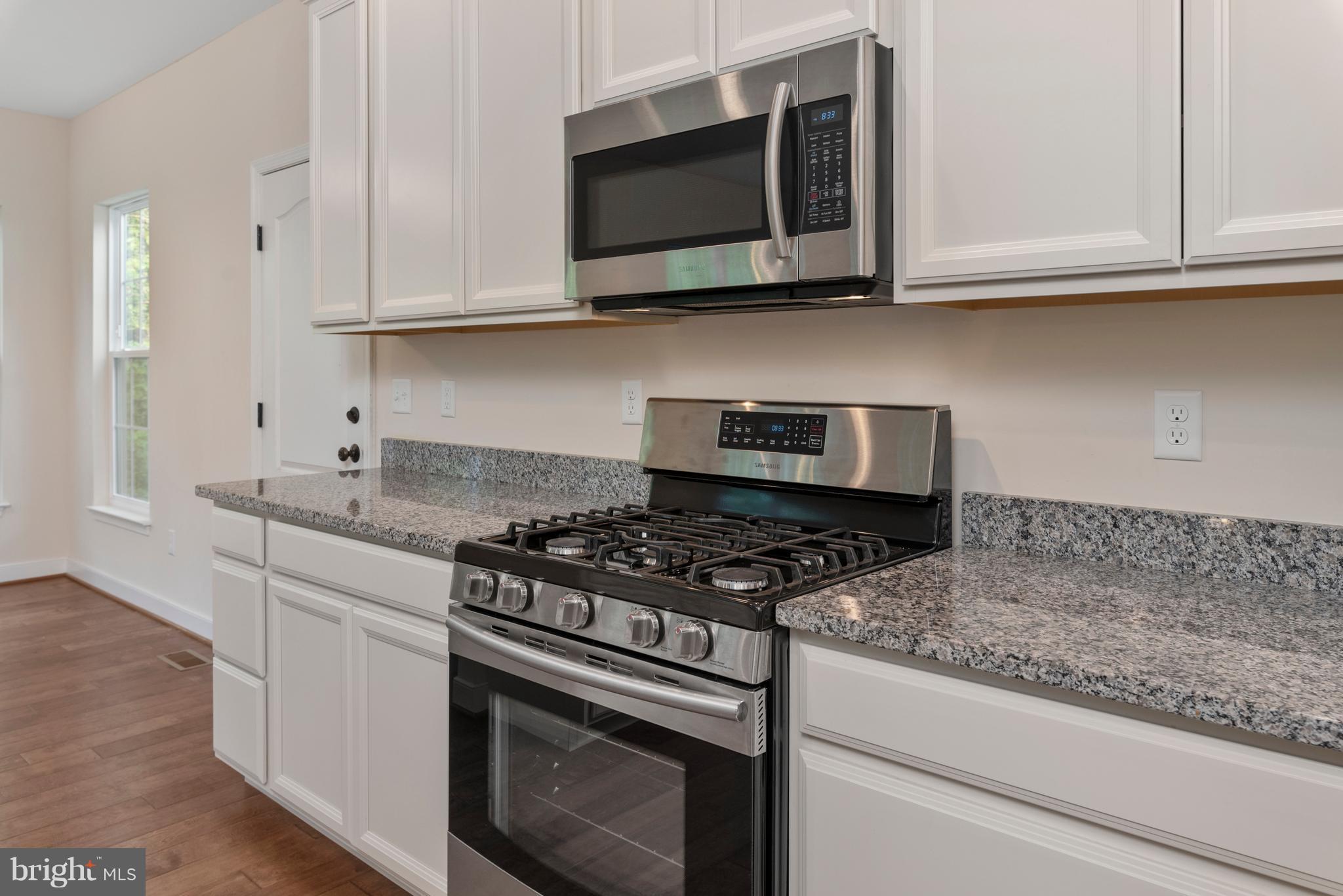 138 Sandy Ridge Road Fredericksburg, VA 22405 - Photo 5 of 30 a kitchen with stainless steel appliances granite countertop white cabinets and a stove top oven