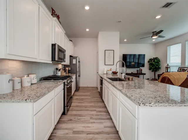 a large kitchen with stainless steel appliances granite countertop a sink stove microwave and cabinets
