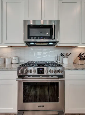 a stove top oven sitting inside of a kitchen