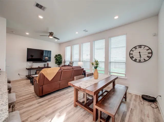 a living room with furniture flat screen tv and a large window