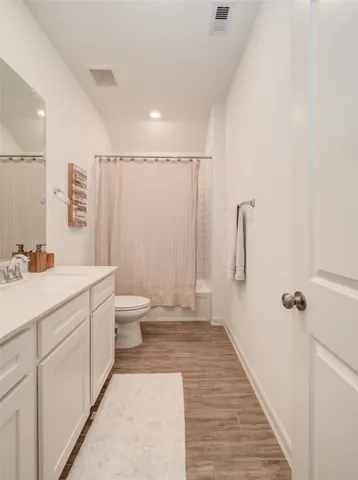 a bathroom with a sink a toilet a mirror and shower