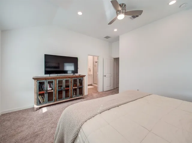 a bedroom with a flat screen tv and a ceiling fan