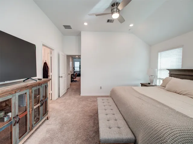 a bedroom with furniture and a flat screen tv