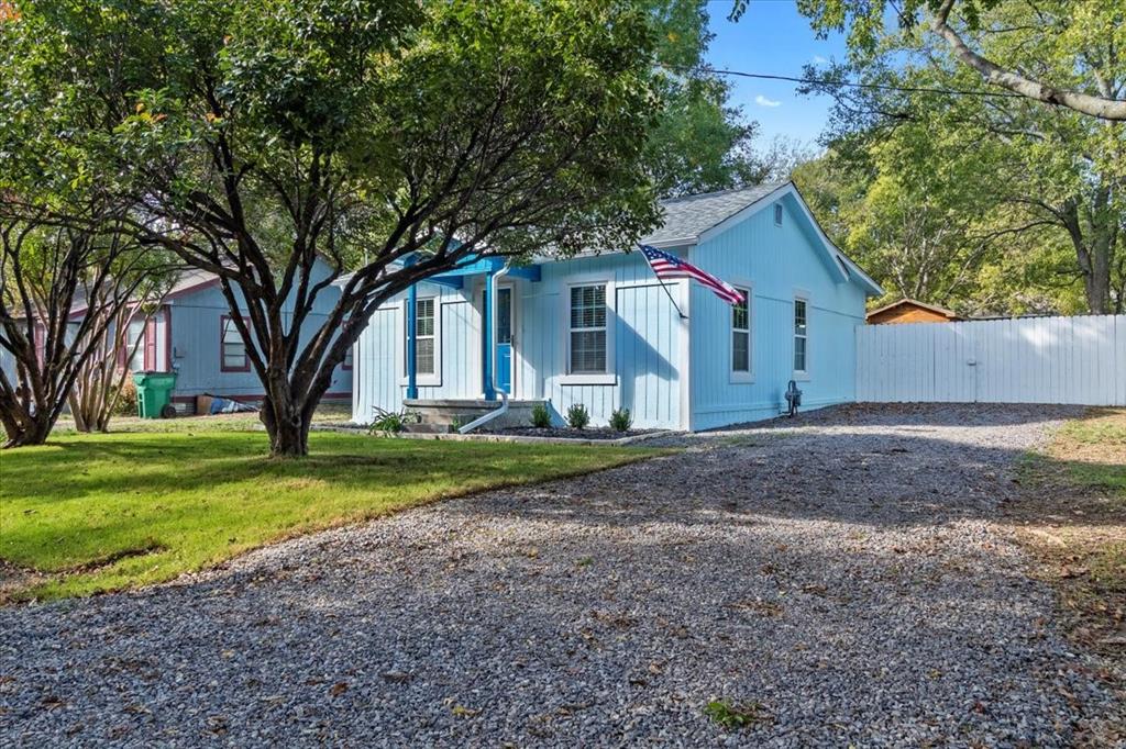 a view of a house with yard and a large tree