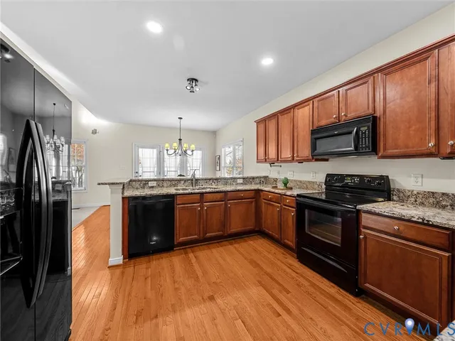 a large kitchen with stainless steel appliances granite countertop a stove cabinets and wooden floor