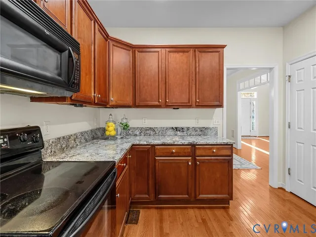 a kitchen with granite countertop wooden cabinets and stainless steel appliances