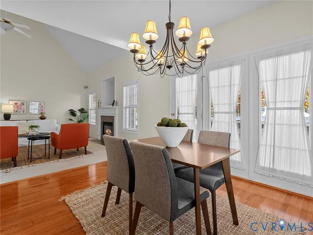 a view of a dining room with furniture a chandelier and wooden floor
