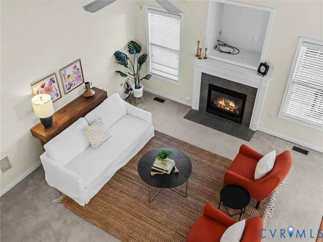 a living room with furniture a fireplace and a potted plant