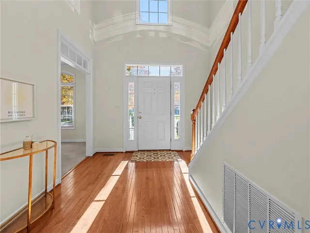 a view of a hallway with wooden floor and staircase