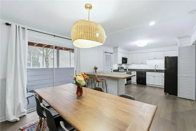 a kitchen with stainless steel appliances a table chairs and chandelier