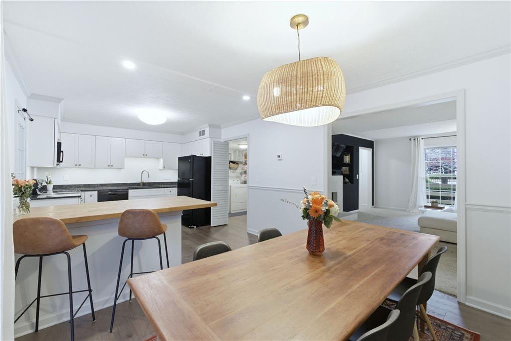 3825 Lavista Road, Unit A1 Tucker, GA 30084 - Photo 14 of 30 a dining room with wooden floor a chandelier a wooden table and chairs