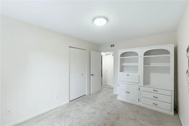 an empty room with cabinet and mirror