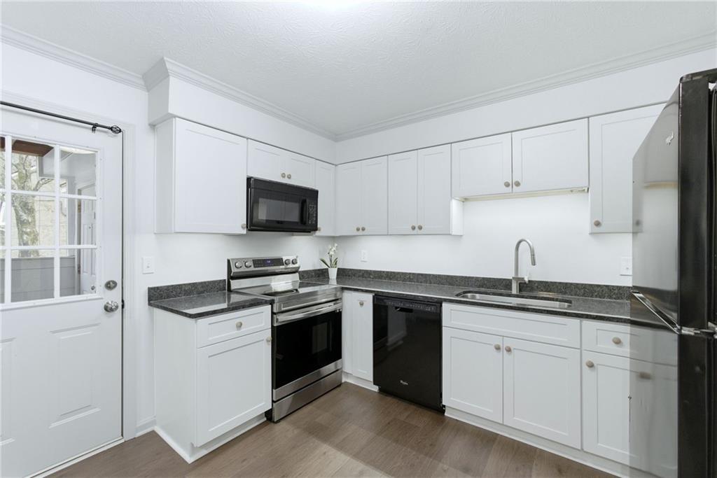 3825 Lavista Road, Unit A1 Tucker, GA 30084 - Photo 7 of 30 a kitchen with stainless steel appliances granite countertop a sink stove and refrigerator