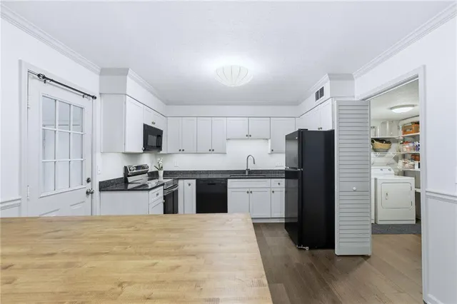 a kitchen with stainless steel appliances granite countertop a refrigerator stove top oven and sink