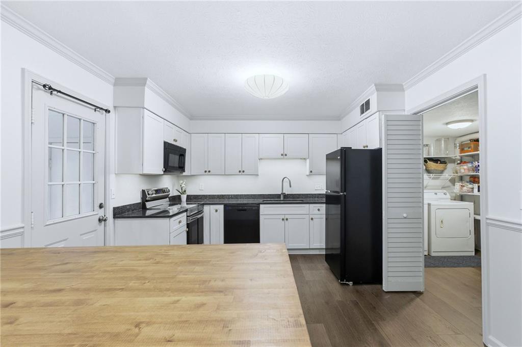 3825 Lavista Road, Unit A1 Tucker, GA 30084 - Photo 9 of 30 a kitchen with stainless steel appliances granite countertop a refrigerator stove top oven and sink